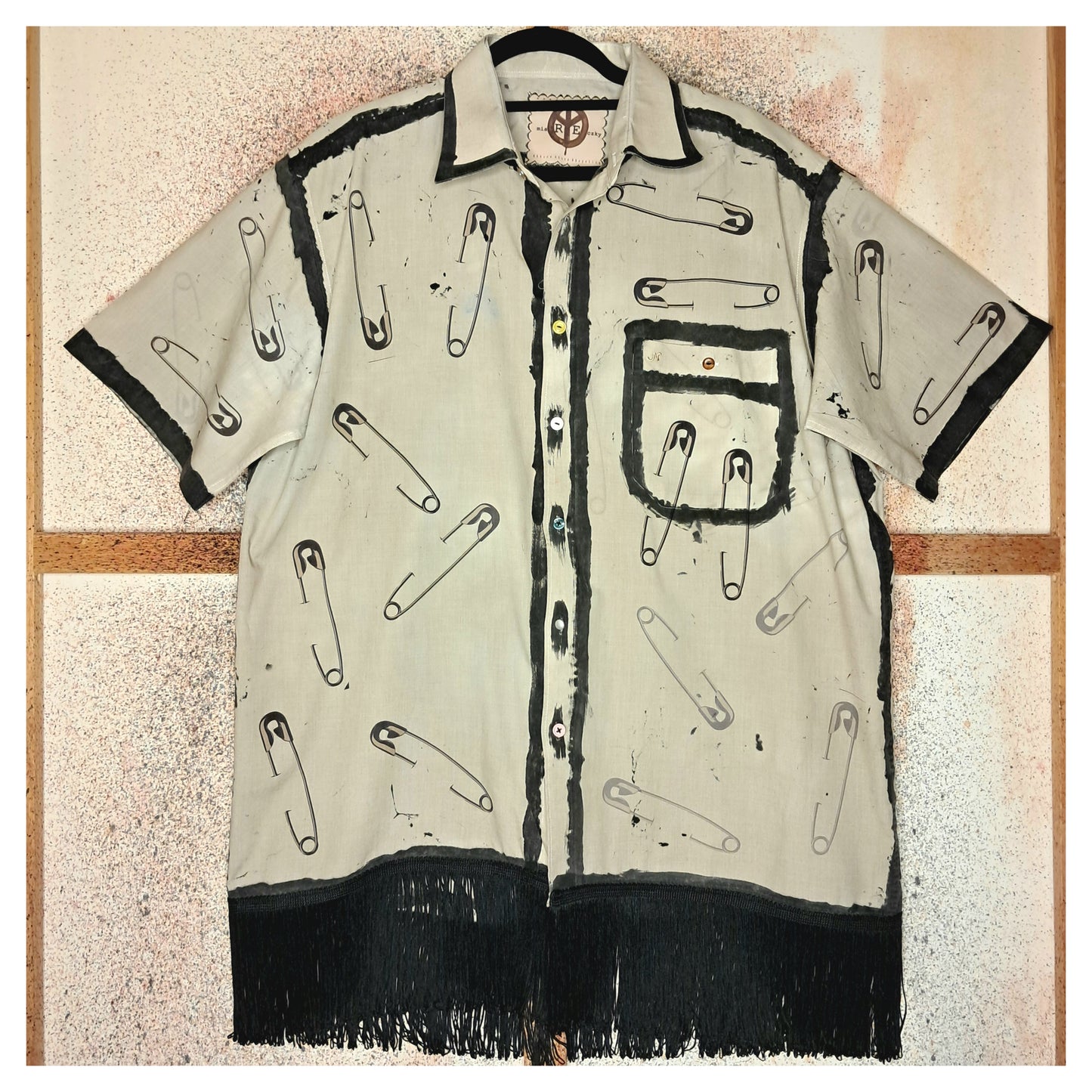 Recycled, upcycled punk short-sleeve shirt with safety pin pattern. Handpainted with black fringe