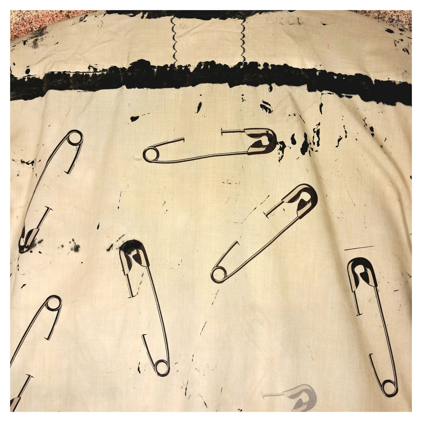 Recycled, upcycled punk beige short-sleeve shirt with safety pin pattern. Handpainted with black fringe and vintage buttons
