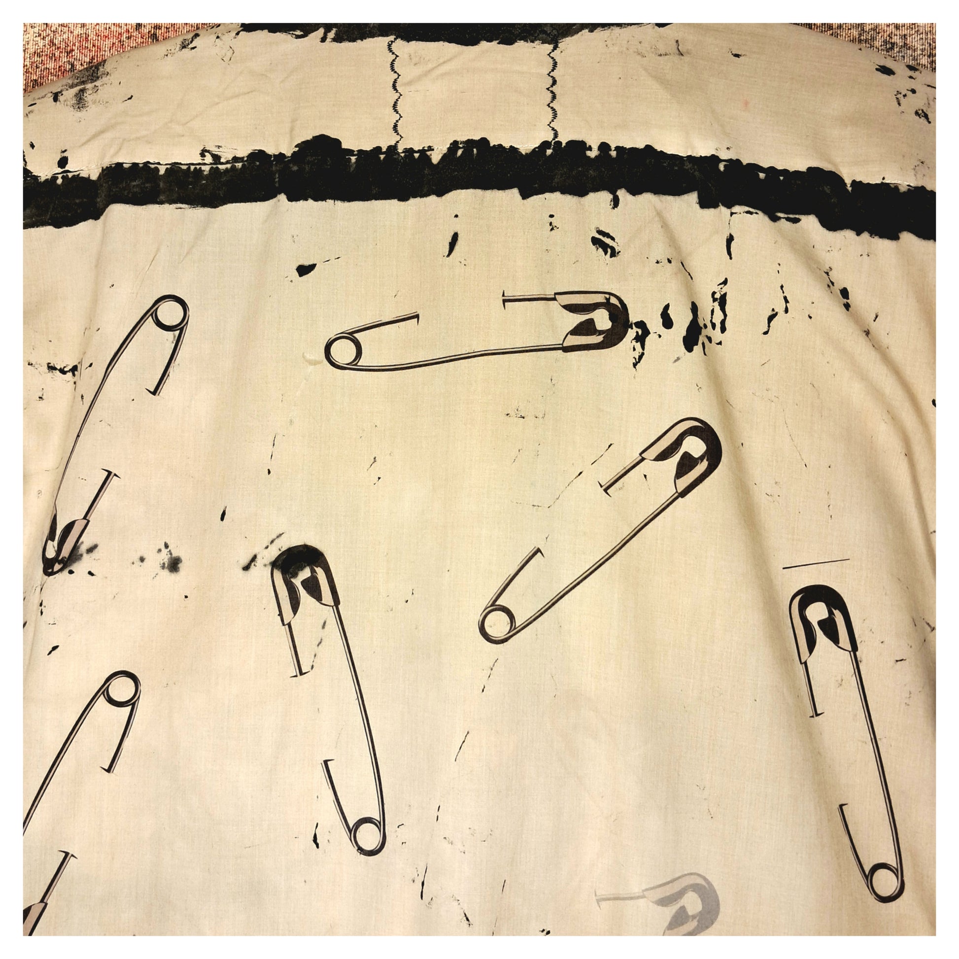 Recycled, upcycled punk beige short-sleeve shirt with safety pin pattern. Handpainted with black fringe and vintage buttons